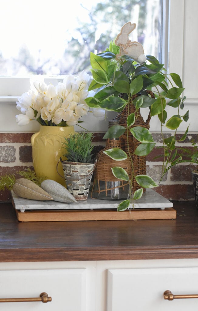 Spring farmhouse kitchen vignette with tulips, greenery and demijohns